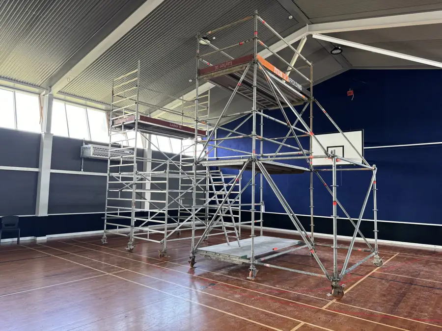 Mobile scaffold tower set up beside a work area