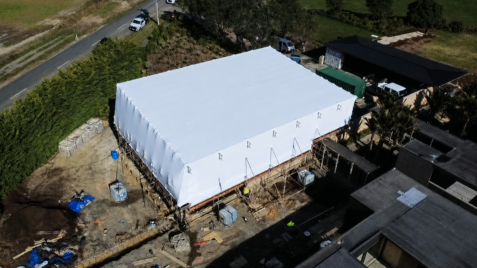 Aerial view of a shrink-wrapped scaffolding project in Karaka